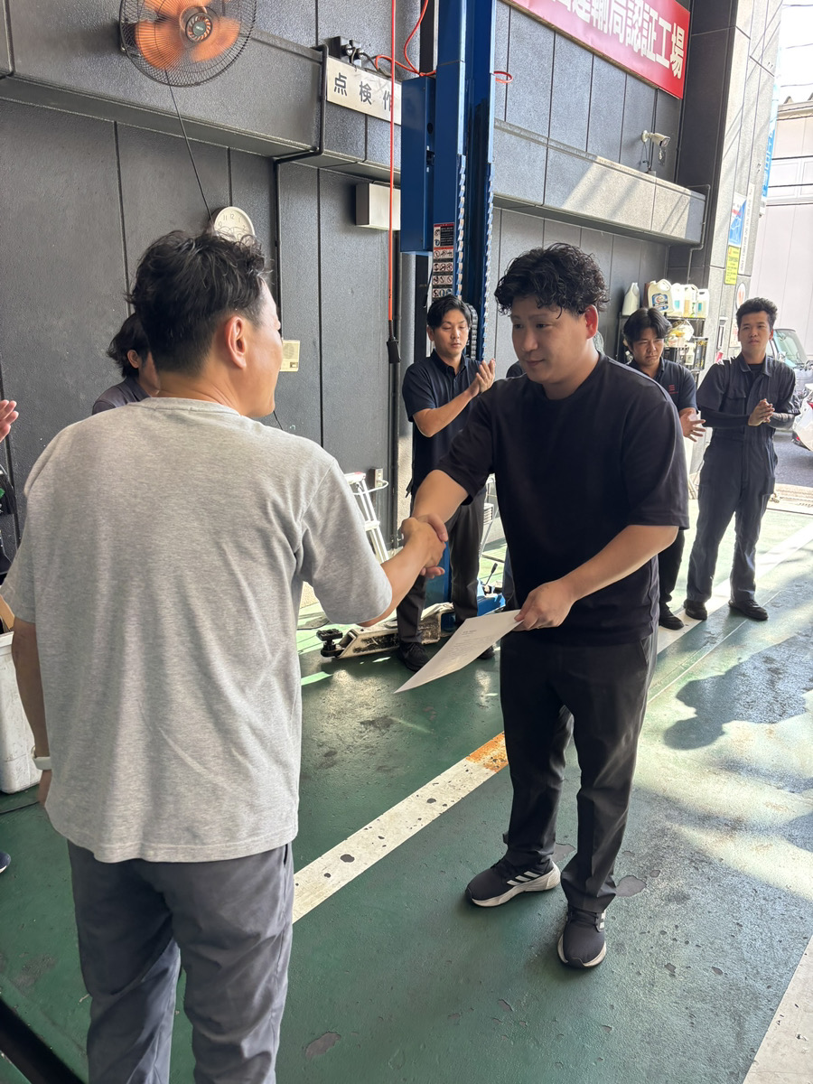 10月1日の辞令交付で津田社長から辞令を受け取る有田統括部長
