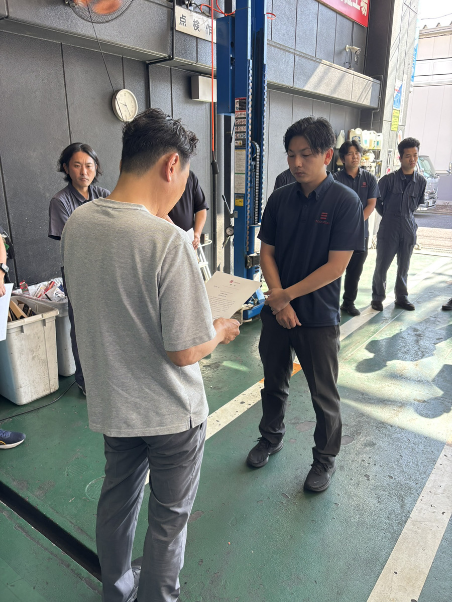 10月1日の辞令交付で津田社長から辞令を受け取る福田店長